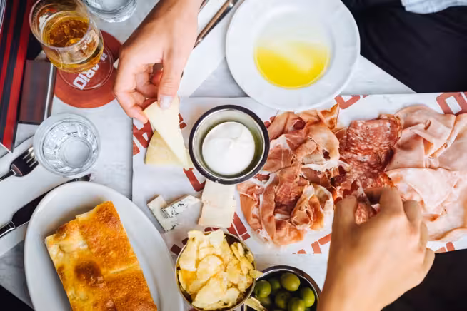 Italian lunch spread with salumi, focaccia, cheese, olives and chips at ilario